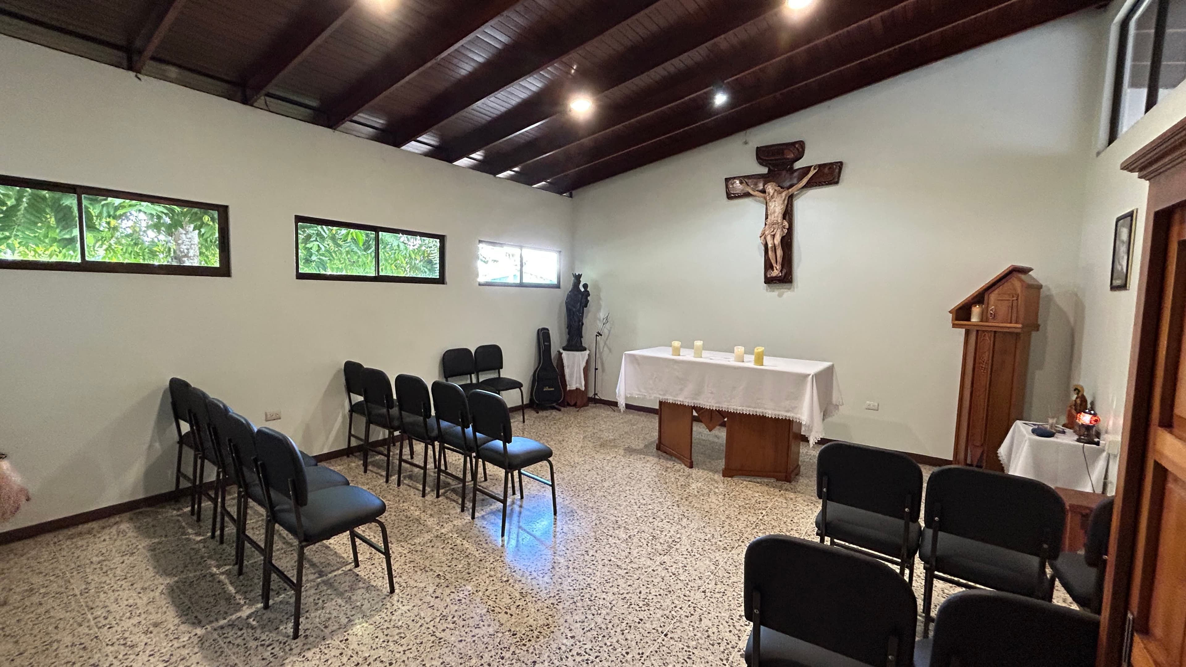 Interior de la Capilla pequeña con altar, crucifijo y área para los participantes