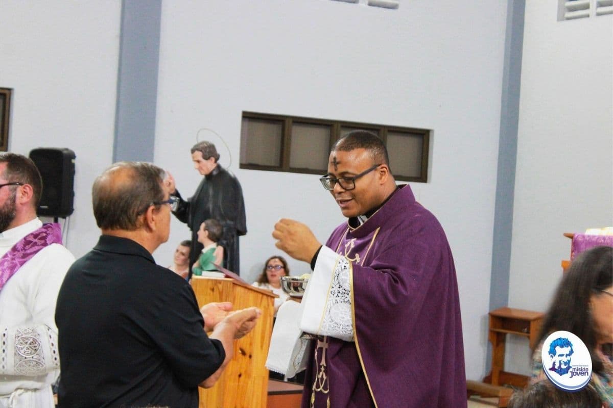 Padre Jean Paul dando la comunión durante la misa en el Centro Don Bosco Pérez Zeledón